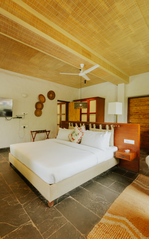 FHR Wilderness Lodge — wide-angle bedroom view with woven rug and warm light